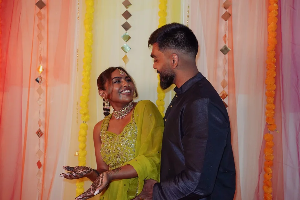 A couple laughing together in front of floral decorations