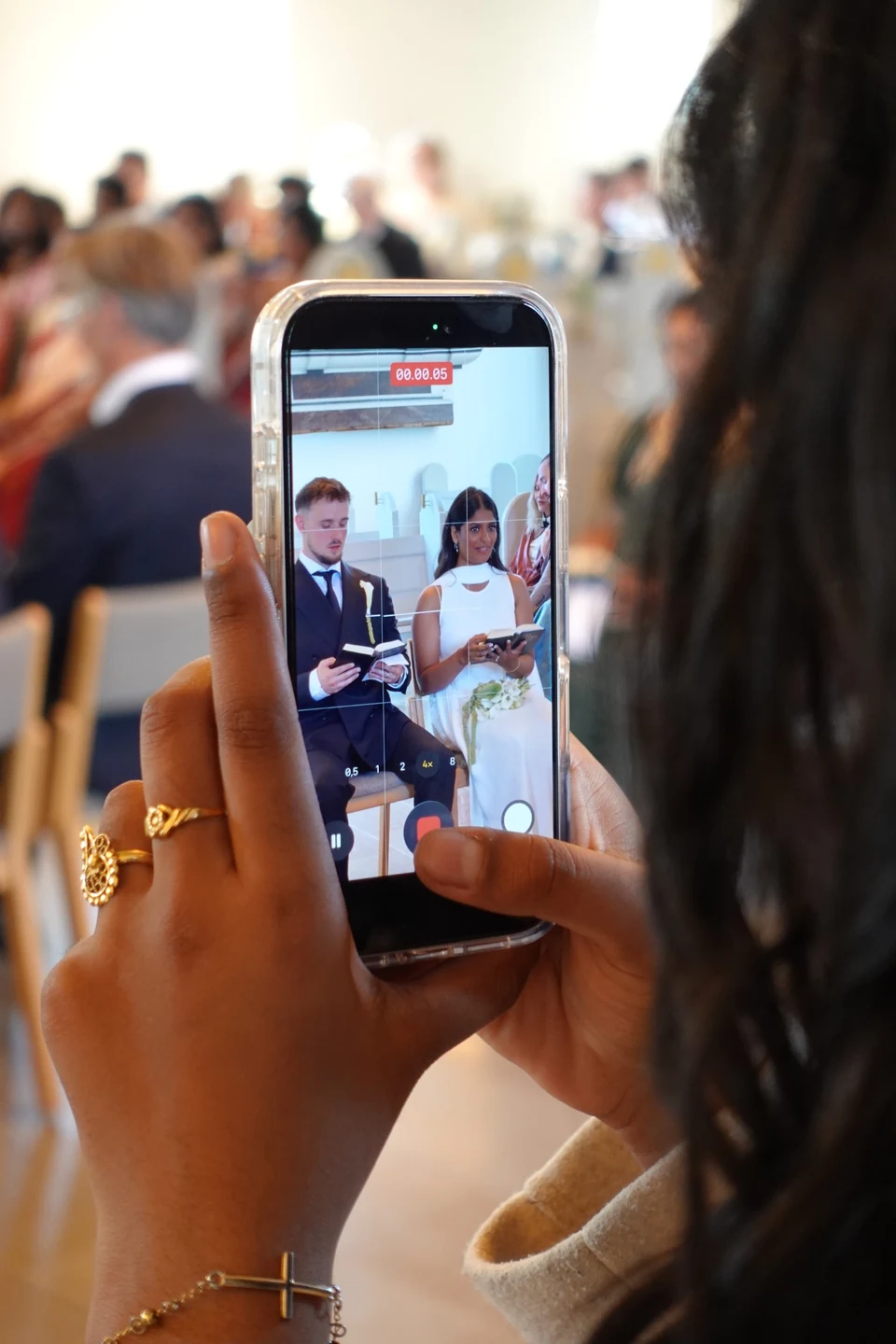 A guest capturing the ceremony on a phone