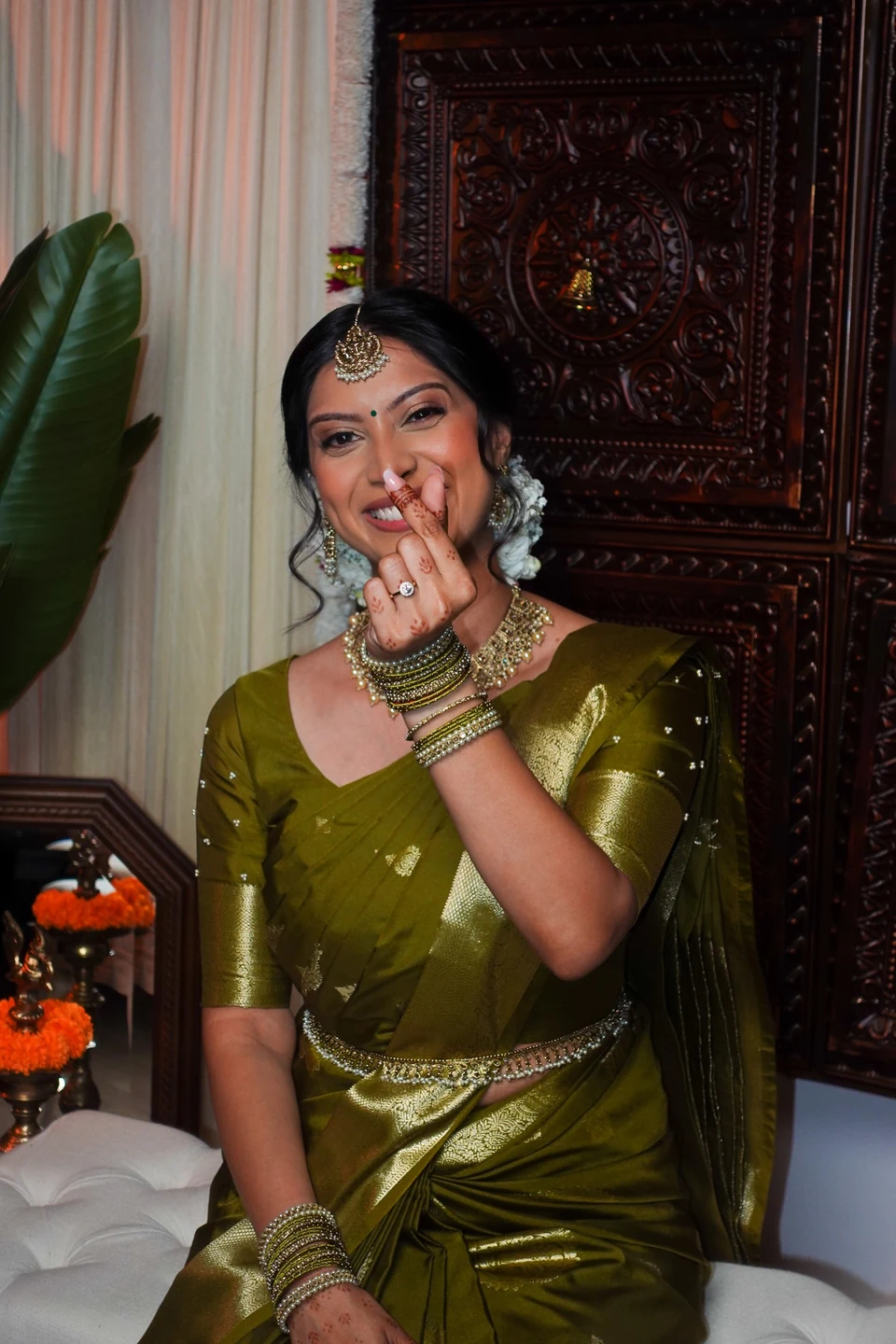 A bride laughing with a hand near her face